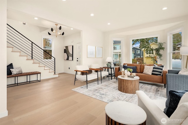 living area featuring recessed lighting, baseboards, light wood-style flooring, and stairs