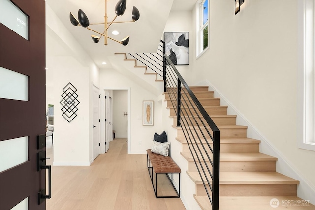 stairs with recessed lighting, wood finished floors, and baseboards