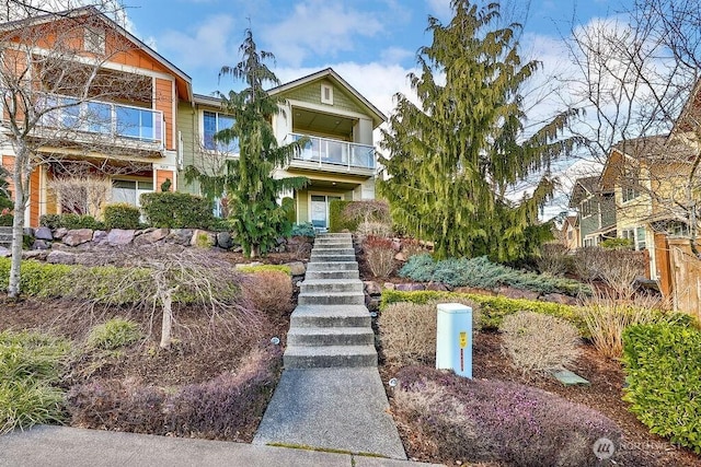 view of front of property with stairway and a balcony