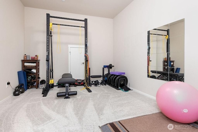 exercise room with baseboards and carpet floors