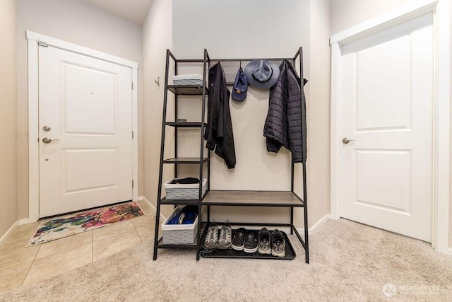 mudroom with tile patterned floors, baseboards, and carpet