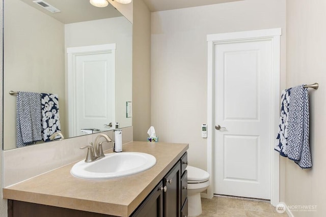 bathroom with visible vents, toilet, and vanity