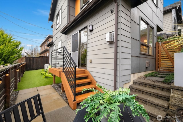 view of property exterior featuring crawl space, a lawn, a wall mounted air conditioner, and fence