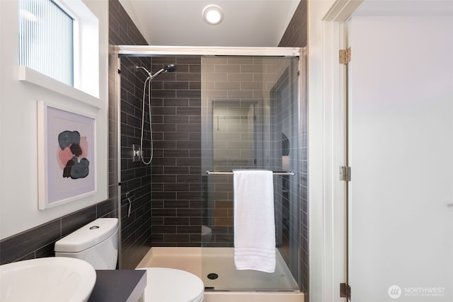 bathroom featuring toilet, a stall shower, and vanity