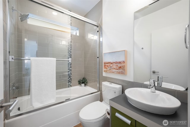 bathroom with vanity, toilet, and enclosed tub / shower combo