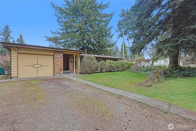 view of front of property with brick siding, a garage, driveway, and a front lawn