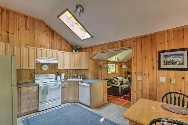 kitchen with white appliances, vaulted ceiling with skylight, light countertops, and under cabinet range hood