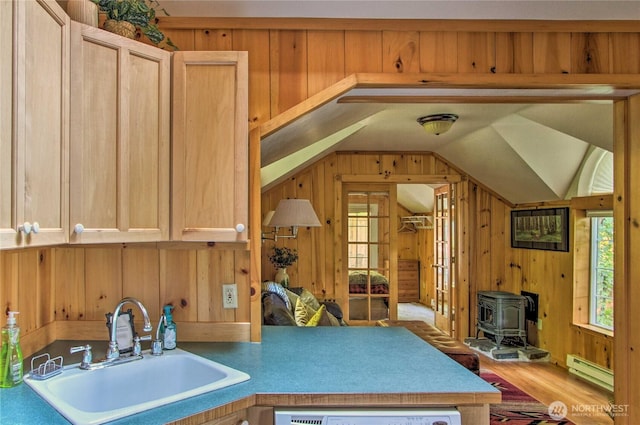 kitchen with a sink, a baseboard heating unit, lofted ceiling, and a healthy amount of sunlight