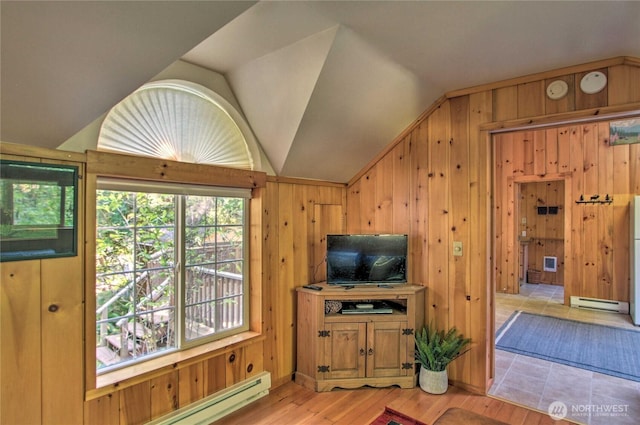 living room with lofted ceiling, light wood-style flooring, wood walls, and baseboard heating