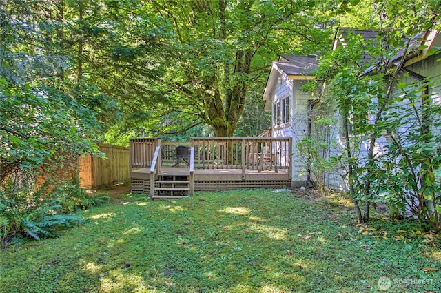 view of yard featuring a wooden deck and fence