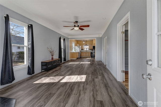 unfurnished living room featuring dark wood finished floors, baseboards, and ceiling fan