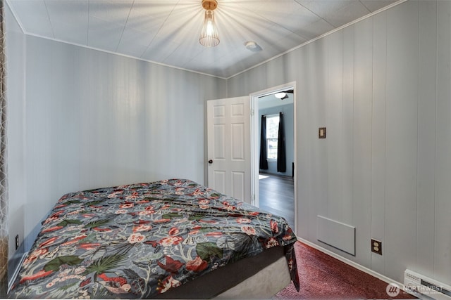 bedroom featuring ornamental molding, dark carpet, and a baseboard radiator