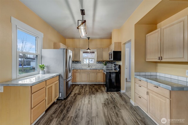 kitchen with light brown cabinets, dark wood-style flooring, stainless steel appliances, decorative light fixtures, and backsplash