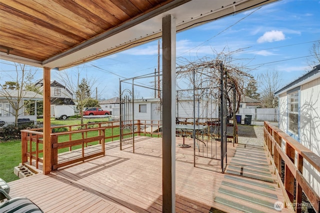 wooden terrace featuring a lawn and fence