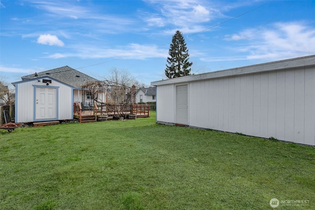 view of yard featuring a storage unit, a deck, and an outdoor structure