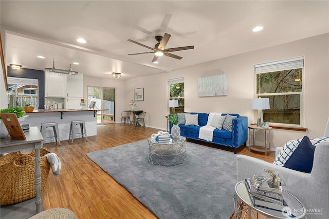 living area featuring recessed lighting, baseboards, wood finished floors, and a ceiling fan