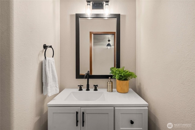 bathroom featuring vanity and a textured wall