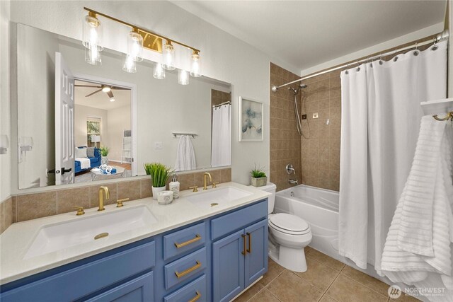 ensuite bathroom with a sink, double vanity, ensuite bath, and tile patterned floors