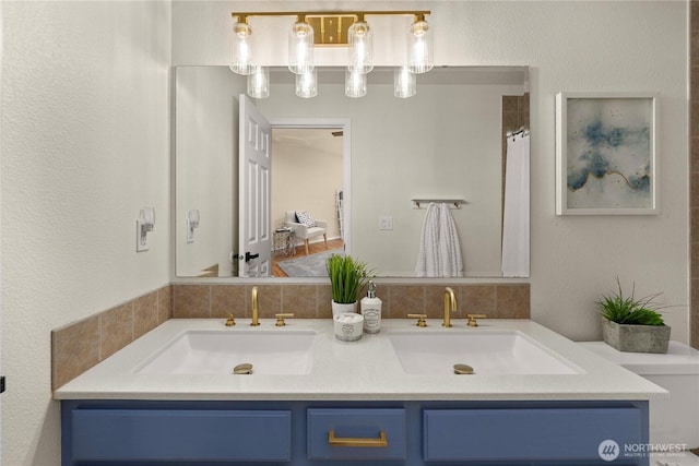 bathroom featuring a sink, a shower with curtain, and double vanity