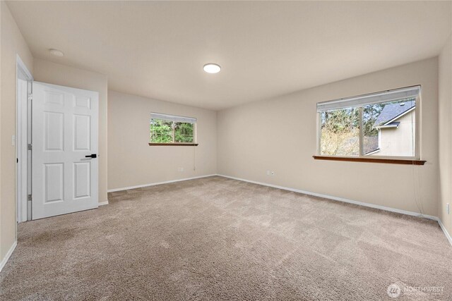 spare room featuring baseboards and carpet flooring