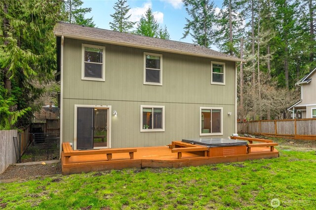 back of house featuring a fenced backyard, a lawn, and a deck