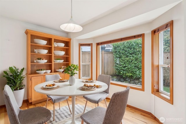 dining area with light wood-style floors and baseboards