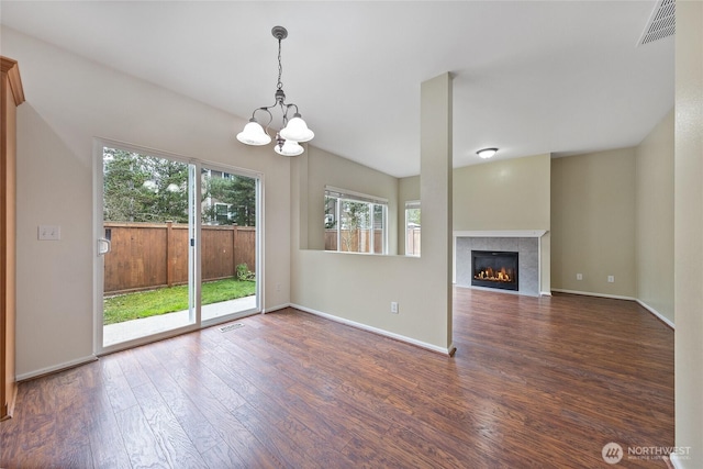 unfurnished living room with visible vents, a fireplace, baseboards, and wood finished floors