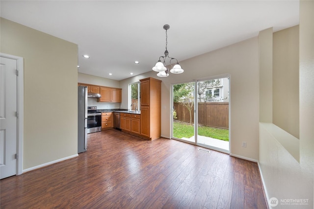 kitchen with under cabinet range hood, dark wood-style floors, baseboards, and appliances with stainless steel finishes