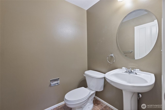 bathroom featuring tile patterned floors, baseboards, and toilet