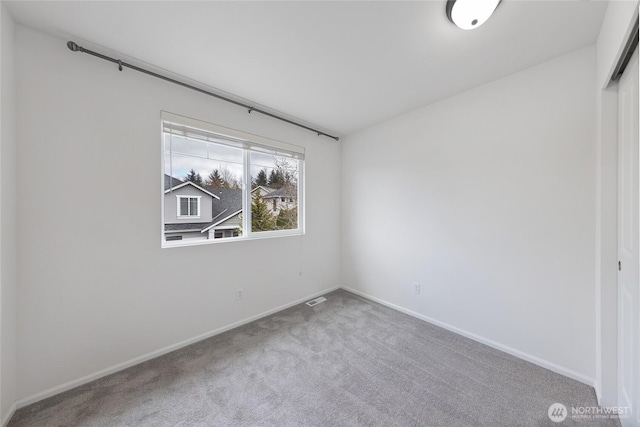 empty room featuring visible vents, baseboards, and carpet