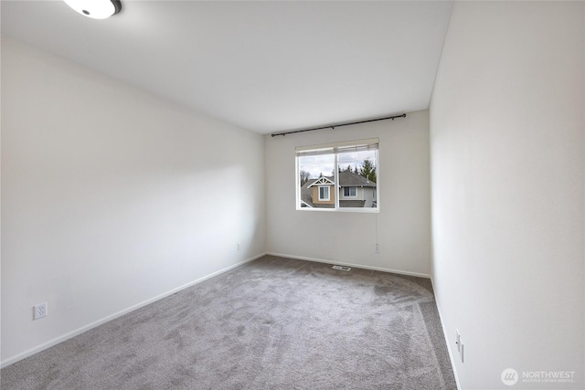 spare room featuring baseboards and carpet flooring