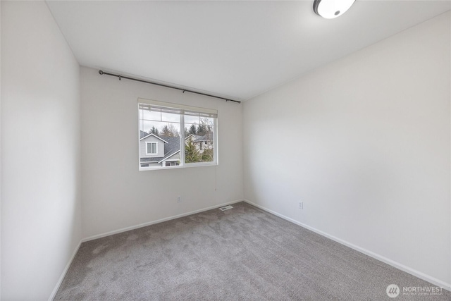 carpeted empty room featuring visible vents and baseboards