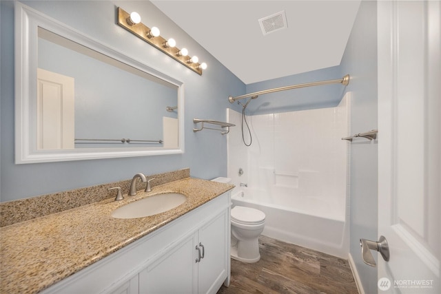 bathroom featuring visible vents, toilet, shower / tub combination, wood finished floors, and vanity