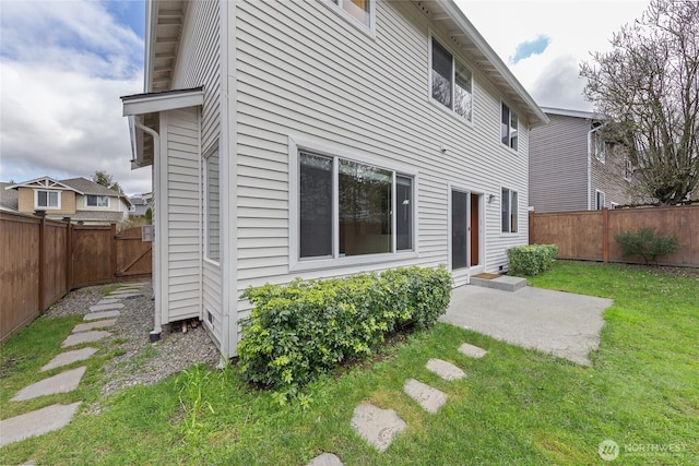 rear view of property featuring a lawn, a patio, and a fenced backyard