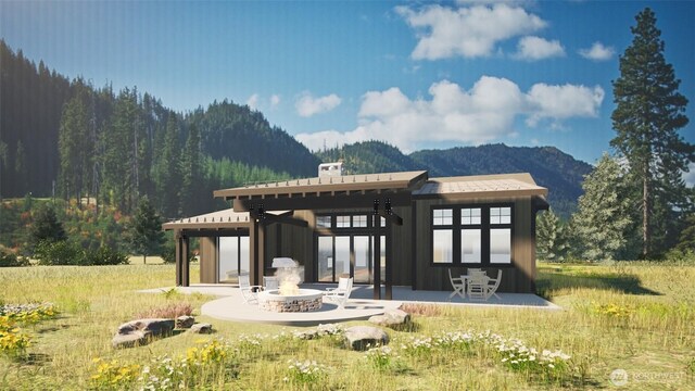 back of property featuring a gazebo, a patio area, a mountain view, and a forest view