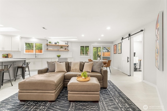 living room with visible vents, recessed lighting, baseboards, and a barn door