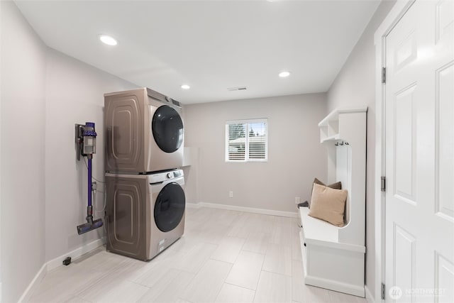 laundry room with recessed lighting, baseboards, laundry area, and stacked washing maching and dryer