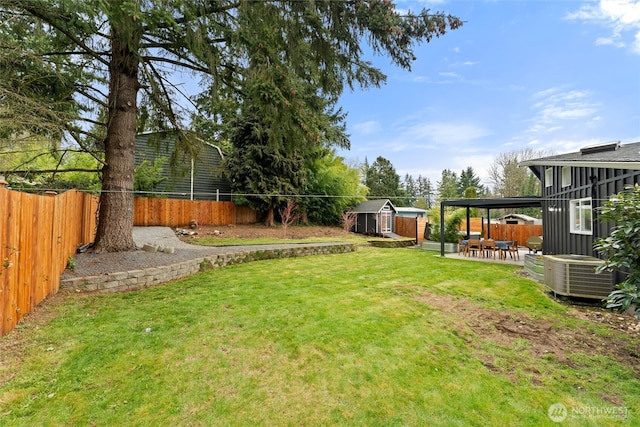 view of yard with a patio, cooling unit, an outbuilding, and a fenced backyard