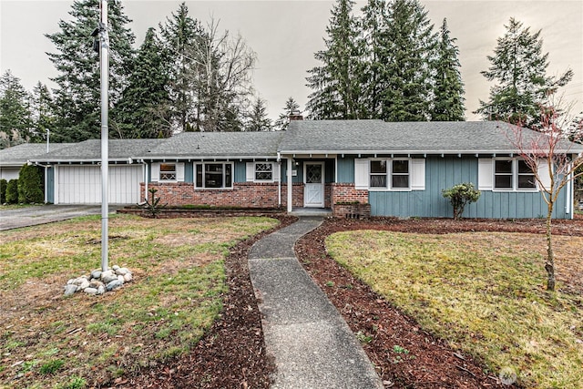 ranch-style house with brick siding, a shingled roof, a front lawn, driveway, and an attached garage