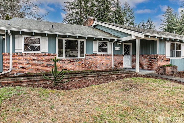 single story home featuring board and batten siding, brick siding, a shingled roof, and a chimney