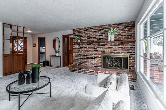 sunken living room featuring visible vents, baseboards, carpet, a fireplace, and a textured ceiling