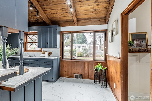 laundry area featuring visible vents, wood walls, wainscoting, wooden ceiling, and marble finish floor