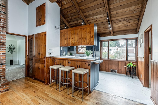 kitchen with visible vents, light wood-style flooring, rail lighting, wood ceiling, and beamed ceiling