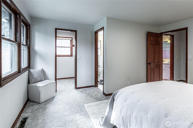 carpeted bedroom with visible vents, baseboards, and ensuite bathroom