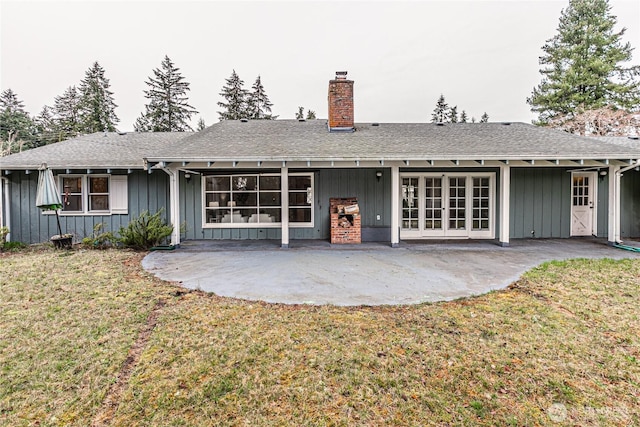 rear view of property with a yard, board and batten siding, and a patio area