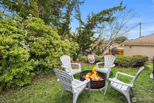 view of yard with fence and an outdoor fire pit