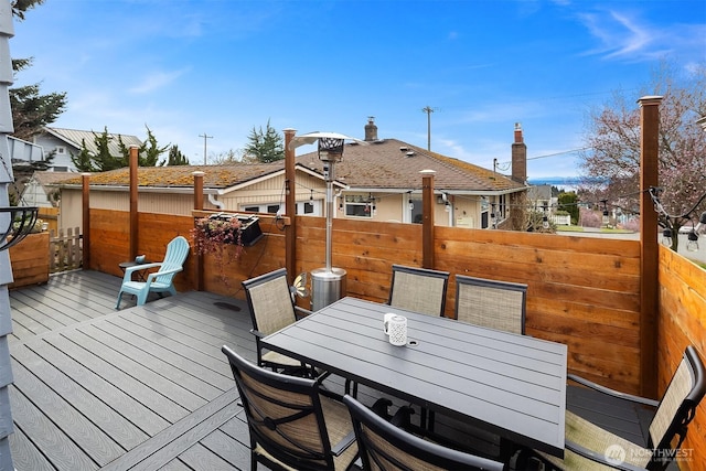 deck with outdoor dining area and fence