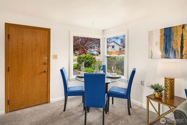 carpeted dining space with baseboards