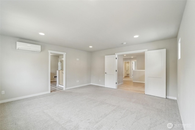 unfurnished bedroom with recessed lighting, baseboards, a wall mounted air conditioner, and light carpet