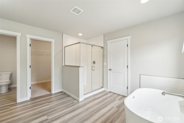 full bath featuring visible vents, recessed lighting, a stall shower, wood finished floors, and a soaking tub